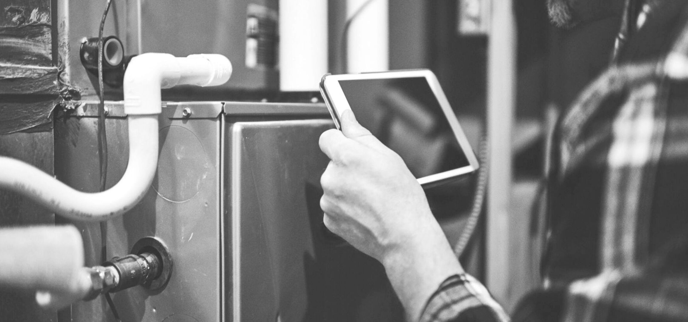 Techniker prüft technische Anlage mit Tablet – digitale Wartung und Sicherheitsprüfung im Betrieb