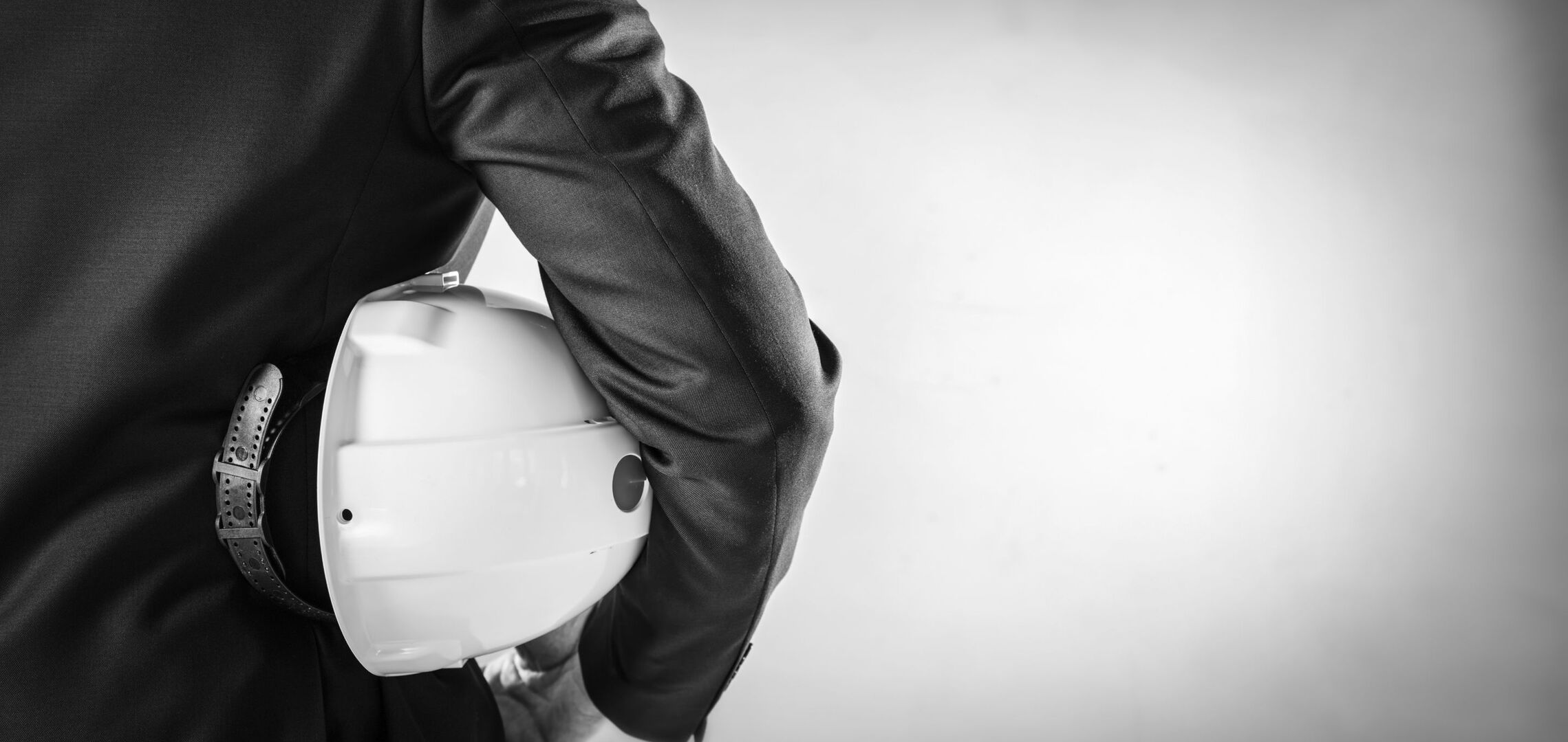 Geschäftsperson mit Schutzhelm steht für Arbeitssicherheit